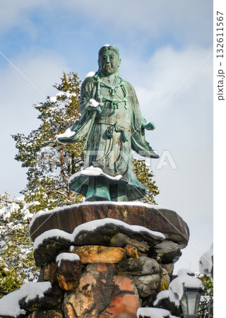 金沢・兼六園の冬、雪化粧を纏い明治紀念之標に佇む日本武尊像の雄姿 132611567
