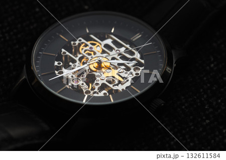 A skeleton watch with intricate gears and metallic movement 132611584