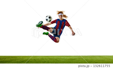 Female soccer player in red and blue uniform performing flying kick on field in professional training session 132611755