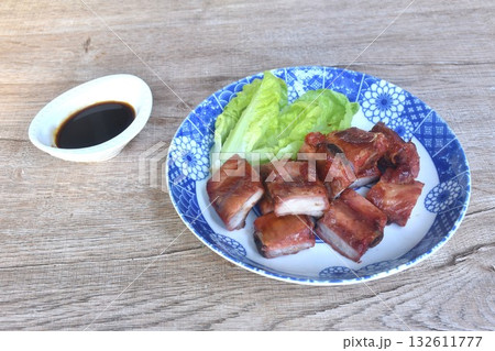 fried crispy pork bone or rib with baby cos lettuce on plate dipping black sweet sauce cup fried crispy pork bone or rib with baby cos lettuce on plate dipping black sweet sauce cup 132611777
