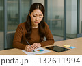 真剣な眼差しで資料に集中する日本人女性マーケ・広報担当 132611994