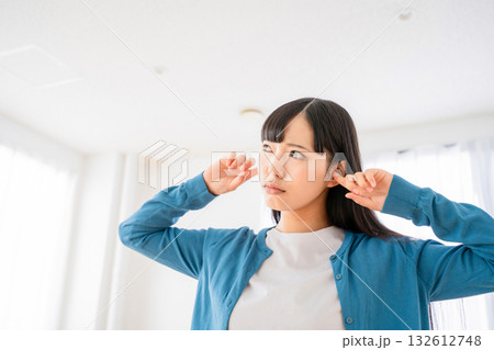耳を塞ぐ若い女性 132612748