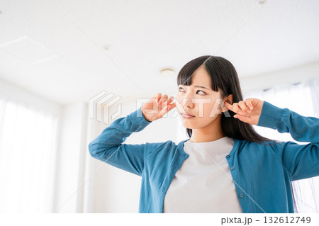 耳を塞ぐ若い女性 132612749