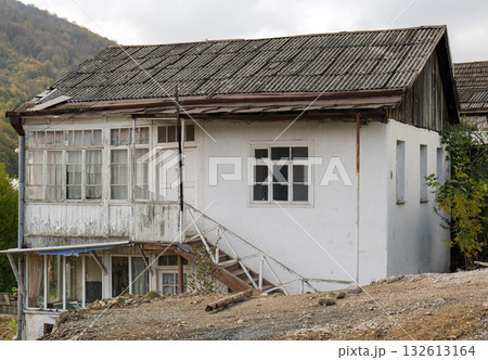 A white house with a blue awning and a white staircase 132613164