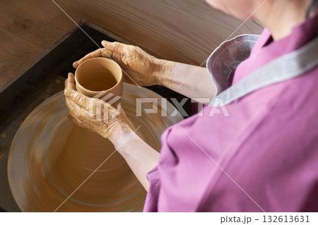 ろくろを使って器を形作る女性の手元 ろくろを使って器を形作る女性の手元 132613631