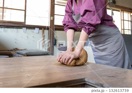 陶芸工房で粘土をこねる女性の手元 132613739