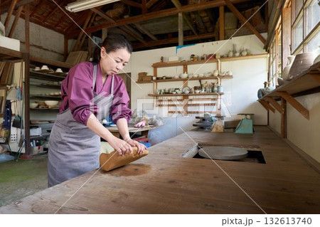 陶芸工房で粘土をこねる女性 132613740