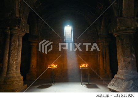 A dark room with a window and two candles lit A dark room with a window and two candles lit 132613926