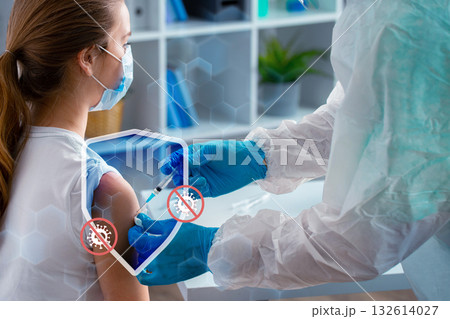Health worker administers vaccine to young girl in medical setting 132614027