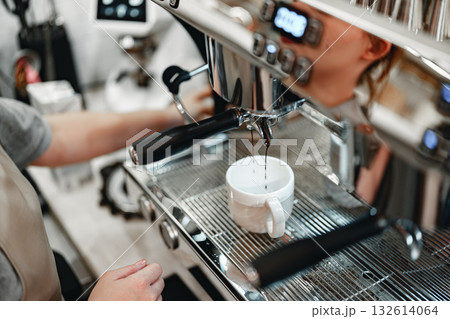Barista prepares espresso in a coffee shop during morning rush hour in the city Barista prepares espresso in a coffee shop during morning rush hour in the city 132614064