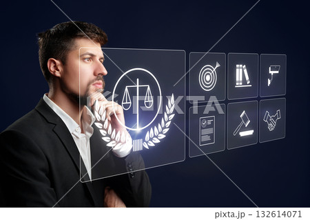 Young professional reflects on legal concepts with digital interface in dark setting Young professional reflects on legal concepts with digital interface in dark setting 132614071