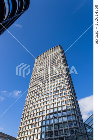 Modern glass skyscraper with geometric facade Modern glass skyscraper with geometric facade 132614569