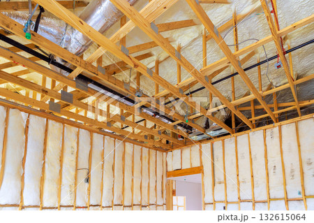 Wooden frame structure insulation materials are indicating ongoing construction work in new home. 132615064