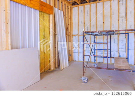 Inside building, wooden beams insulation are with scaffolding set up for renovation work. Inside building, wooden beams insulation are with scaffolding set up for renovation work. 132615066