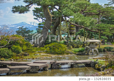 金沢・兼六園の雁行橋と徽軫灯籠、遠くに冠雪した医王山を望む冬の庭園美 132616035