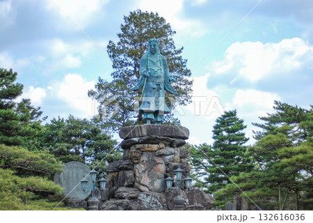 金沢・兼六園に建つ明治紀念之標の日本武尊像と周囲を彩る見事な枝振りの松 132616036