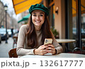 attractive young blond woman sitting in cafe using smart phone drinking coffee in spring summer autumn fashion trend outfit smiling happy in beige suit street style, laughing taking pictures on camera 132617777