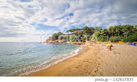 Sunny coastal panorama of Cala Bona, Sant Francesc bay in Blanes, Costa Brava, Spain. A picturesque cove famous for its golden sand, crystal-clear water, and stunning rocky cliffs with pine trees Sunny coastal panorama of Cala Bona, Sant Francesc bay in Blanes, Costa Brava, Spain. A picturesque cove famous for its golden sand, crystal-clear water, and stunning rocky cliffs with pine trees 132617835