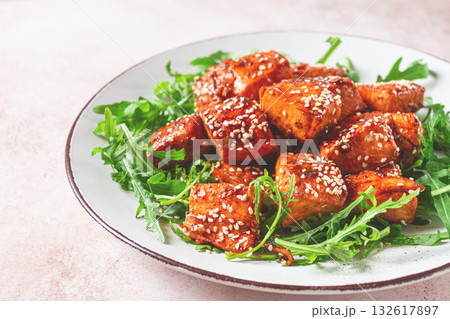 fried salmon slices, teriyaki with sesame seeds, with arugula salad, top view, fried salmon slices, teriyaki with sesame seeds, with arugula salad, top view, 132617897