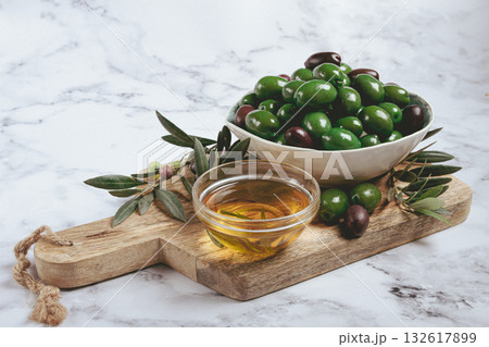Chalkidiki olives, classic Greek green olives, in a bowl on a cutting board, top view, without people, Chalkidiki olives, classic Greek green olives, in a bowl on a cutting board, top view, without people, 132617899