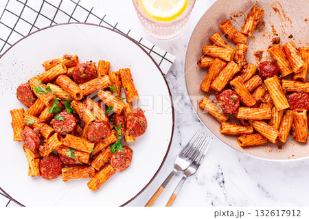 rigatoni pasta with spicy sausage, and rich tomato sauce served, on a white plate, homemade, rigatoni pasta with spicy sausage, and rich tomato sauce served, on a white plate, homemade, 132617912