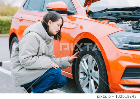 車のトラブルで困った様子の若い女性ドライバー 132618245