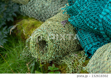 Stacked fishing nets in various colors and textures create a nice, vibrant, detailed composition of maritime life. Stacked fishing nets in various colors and textures create a nice, vibrant, detailed composition of maritime life. 132618302