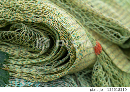Stacked fishing nets in manycolors and textures create a vibrant, detailed composition of maritime life. 132618310