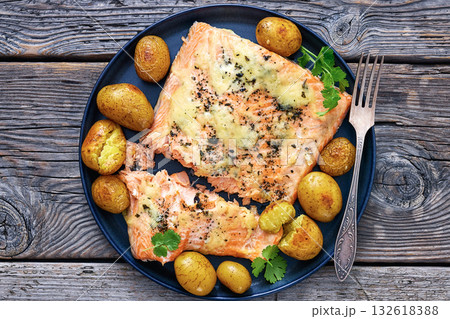 Salmon fillet with cheese, spices, baby potatoes 132618388