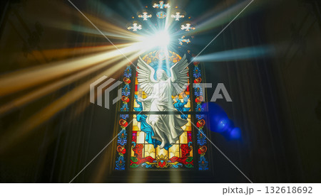 A ray of bright sun passes through the stained glass of the cathedral, as a sign of God, shimmering and shining in the glass, Catholic faith. 132618692