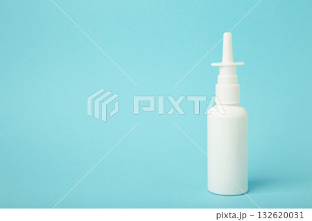Nasal drops medicine bottle on blue background. Space for text 132620031