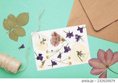 Pressed and dried flowers with twine on mint background. For use in scrapbooking, floristry or herbarium. Pressed and dried flowers with twine on mint background. For use in scrapbooking, floristry or herbarium. 132620074