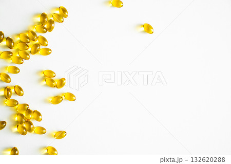 Golden vitamin capsules arranged on white background with copy space Golden vitamin capsules arranged on white background with copy space 132620288