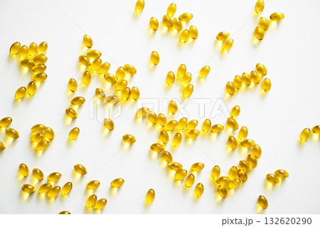 Scattered omega capsules on bright white background with soft light 132620290