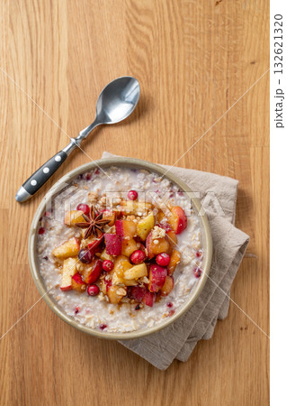 Overnight oatmeal with apple, cranberry and cinnamon in a plate on a wooden background with spoon Overnight oatmeal with apple, cranberry and cinnamon in a plate on a wooden background with spoon 132621320