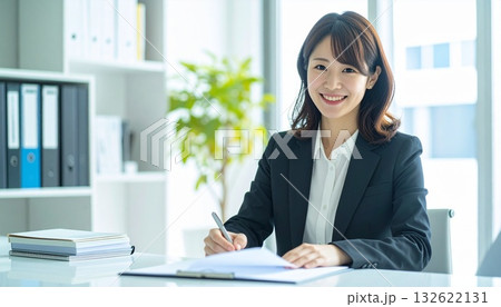 書類にサインやメモをする笑顔のビジネスパーソン  132622131