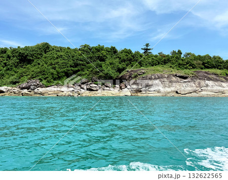 Rocky tropical coastline with lush greenery seen from a boat on a sunny day. Travel, nature and adventure concept.  132622565