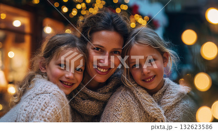 Mother and daughters enjoying festive bonding, warmth, and holiday cheer, smiling together among glowing atmospheric lights 132623586