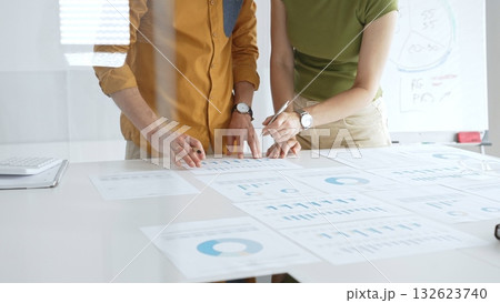 Business team members are reviewing financial data, analyzing charts and graphs, during a productive meeting in a modern office space Business team members are reviewing financial data, analyzing charts and graphs, during a productive meeting in a modern office space 132623740