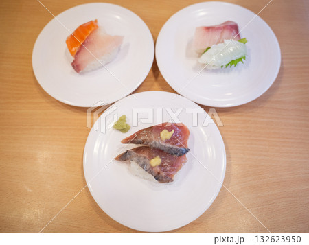 【日本】回転寿司屋のテーブル上に並ぶマグロやサーモンの握り寿司 132623950