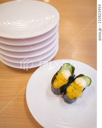 【日本】回転寿司屋のテーブル上に並ぶ軍艦巻きと食べ終わって積み上げられたたくさんの皿 【日本】回転寿司屋のテーブル上に並ぶ軍艦巻きと食べ終わって積み上げられたたくさんの皿 132623954