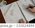 建築士が方眼ノートにプランを検討している手元の風景 132624894