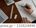 建築士が方眼ノートにプランを検討している手元の風景 132624896