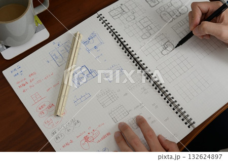 建築士が方眼ノートにプランを検討している手元の風景 132624897