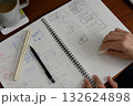 建築士が方眼ノートにプランを検討している手元の風景 132624898