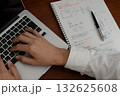 建築士がノートに設計メモを書く手とノートパソコンのあるデスク 132625608