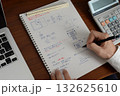 建築士がノートに設計メモを書く手とノートパソコンのあるデスク 132625610