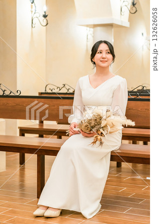 結婚式場,チャペルのベンチに座る新婦,花嫁（バージンロード・教会・チャペル） 132626058