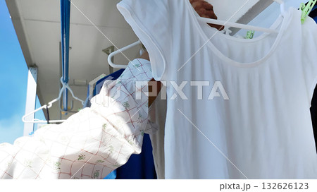 ベランダで洗濯物を干す高齢男性の手 132626123