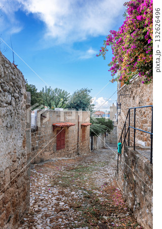 Street view of old town of Rhodes, Greece. Paved roads and pavements with colorful houses and fragrant flowers. High quality photo 132626496